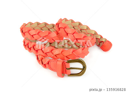 Braided coral pink leather belt with antique bronze buckle isolated on white. 135916828