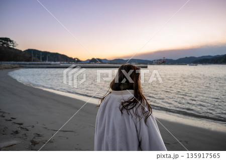 夕方の海と空と若い女性 135917565