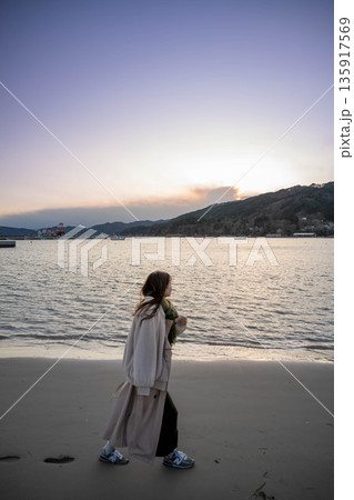 夕方の海と空と若い女性 135917569