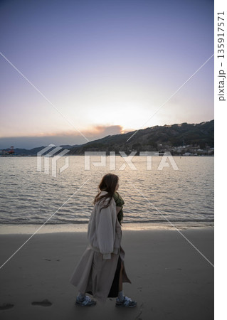 夕方の海と空と若い女性 135917571
