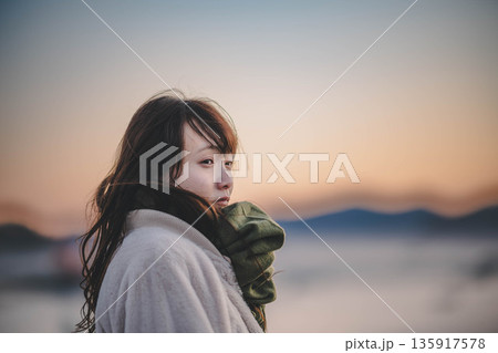 夕方の海と空と若い女性 135917578