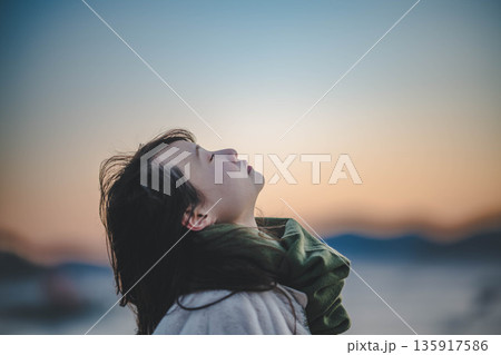 夕方の海と空と若い女性 135917586