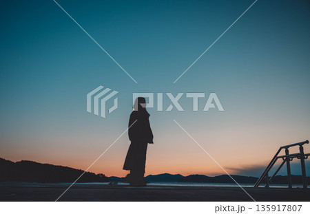 夕方の幻想的な空と女性 135917807