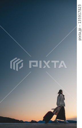 夕方の幻想的な空と女性 135917823