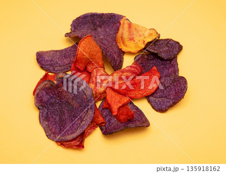 Colorful potato chips pile on yellow Colorful potato chips pile on yellow 135918162
