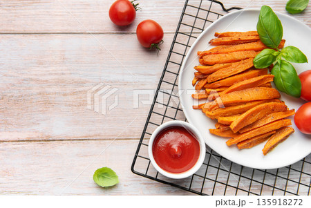 Sweet potato fries with ketchup and fresh basil 135918272