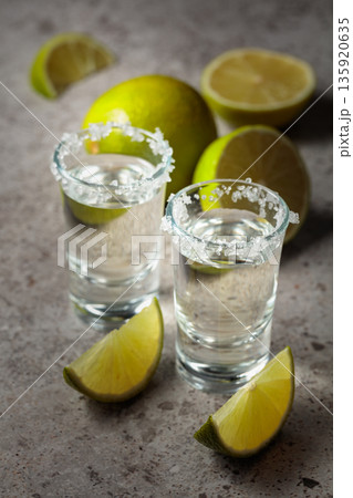 Tequila with salt and lime slices. 135920635