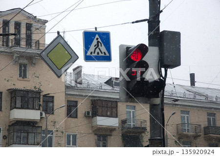 A traffic light and road signs against the backdrop of a residential building A traffic light and road signs against the backdrop of a residential building 135920924