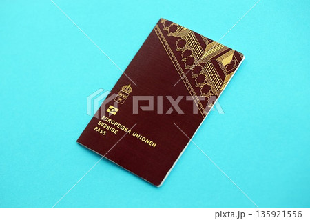 Swedish biometrical passport on light blue table background. Concept of citizenship of Sweden 135921556