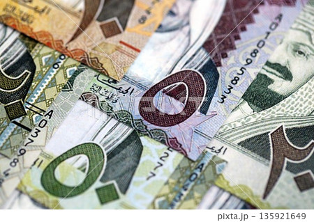 Saudi Arabia riyal money bills banknotes lies in big pile on table close up. Concept of finances and business in Saudi Arabia 135921649