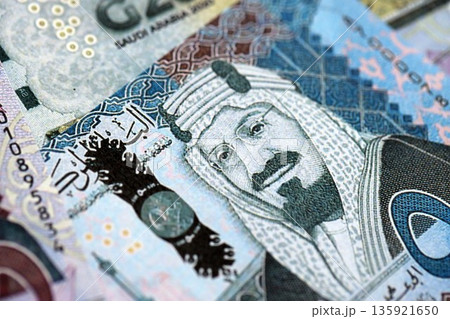 Saudi Arabia riyal money bills banknotes lies in big pile on table close up. Concept of finances and business in Saudi Arabia Saudi Arabia riyal money bills banknotes lies in big pile on table close up. Concept of finances and business in Saudi Arabia 135921650