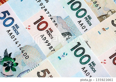 Colombian pesos money bills banknotes lies in big pile on table close up. Concept of finances and business in Colombia 135921661