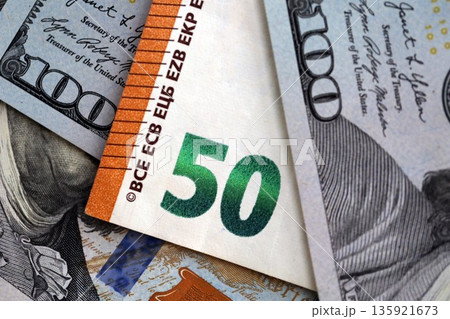 One hundred US dollar bill banknotes and fifty european Euro currency banknote. Concept of currency exchange between USD and EUR 135921673