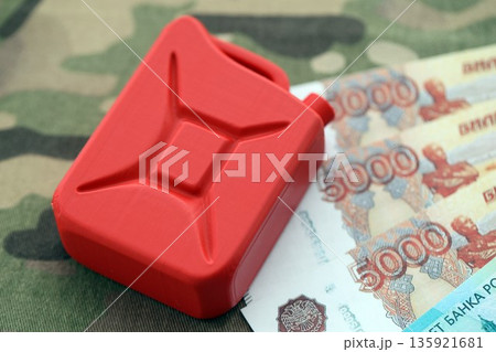 Petrol canister on russian roubles money bills on camouflage fabric. Concept of petroleum export from Russia 135921681