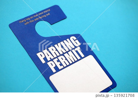 Parking permit paper notice tag for car interior close up. Parking permit for people with disabilities concept. Vip private parking Parking permit paper notice tag for car interior close up. Parking permit for people with disabilities concept. Vip private parking 135921708