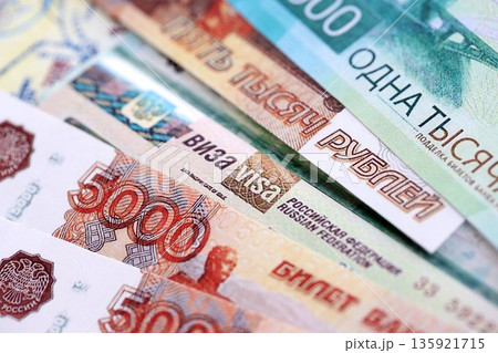 Fragment of Russian Federation visa in passport page and russian rubles money bills close up. Concept of travel and tourism worldwide Fragment of Russian Federation visa in passport page and russian rubles money bills close up. Concept of travel and tourism worldwide 135921715