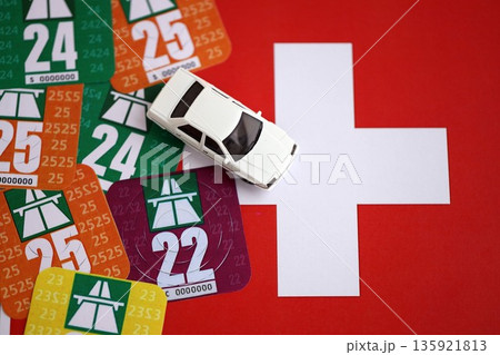 Switzerland vignette stickers for different years with toy car on Swiss flag close up. Driving permit and registration concept Switzerland vignette stickers for different years with toy car on Swiss flag close up. Driving permit and registration concept 135921813