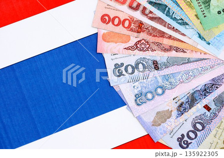 Thai baht currency money bills lies on flag close up. The concept of business and investment 135922305