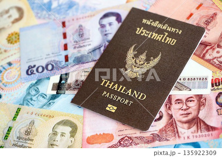 Thai baht currency money bills and passport close up. The concept of travel and vacation Thai baht currency money bills and passport close up. The concept of travel and vacation 135922309