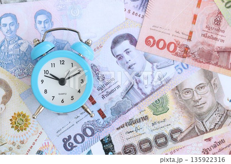 Thai baht currency money bills and alarm clock close up. The concept of time management and income 135922316