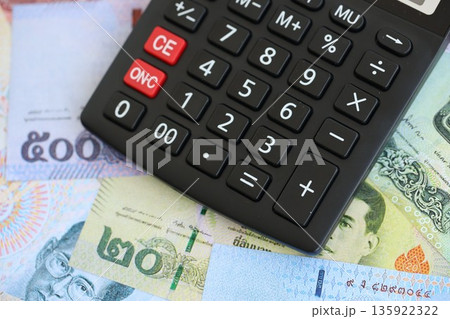 Thai baht currency money bills and calculator close up. The concept of taxation and money count Thai baht currency money bills and calculator close up. The concept of taxation and money count 135922322