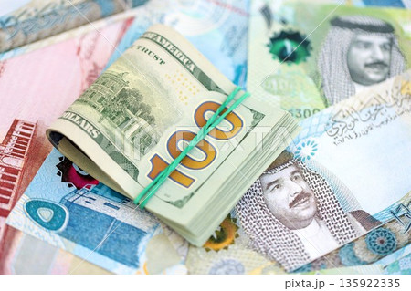 Bahraini dinar currency money bills and bunch of us dollar banknotes close up. The concept of economics and currency exchange Bahraini dinar currency money bills and bunch of us dollar banknotes close up. The concept of economics and currency exchange 135922335