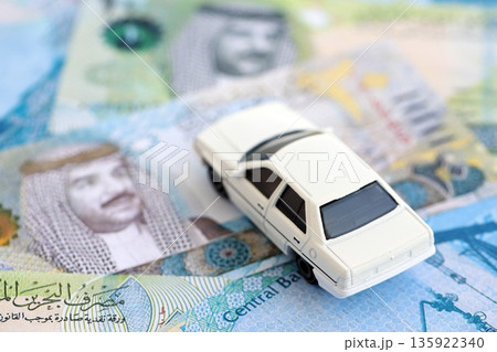 Bahraini dinar currency money bills and toy car close up. The concept of car ownership Bahraini dinar currency money bills and toy car close up. The concept of car ownership 135922340