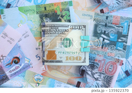 Kuwaiti dinar currency money bills and bunch of us dollar banknotes close up. The concept of economics and currency exchange Kuwaiti dinar currency money bills and bunch of us dollar banknotes close up. The concept of economics and currency exchange 135922370