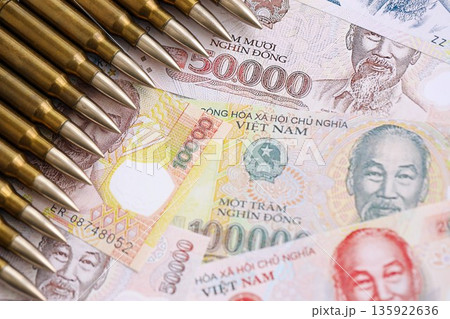 Vietnamese dong currency money bills and rifle bullets close up. The concept of warfare and gun selling 135922636