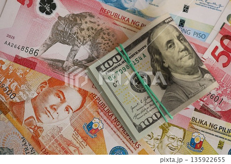 Philippines peso currency money bills and bunch of us dollar banknotes close up. The concept of economics and currency exchange 135922655