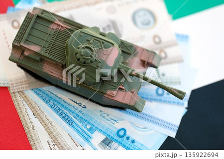 United Arab Emirates dirham currency money bills and toy tank on flag close up. The concept of army funds and weapons sales 135922694