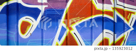 Colorful background of graffiti painting artwork with bright aerosol outlines on wall. Old school street art piece made with aerosol spray paint cans. Contemporary youth culture backdrop 135923012