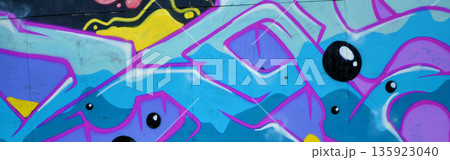 Colorful background of graffiti painting artwork with bright aerosol outlines on wall. Old school street art piece made with aerosol spray paint cans. Contemporary youth culture backdrop 135923040