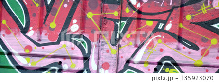 Colorful background of graffiti painting artwork with bright aerosol outlines on wall. Old school street art piece made with aerosol spray paint cans. Contemporary youth culture backdrop 135923070