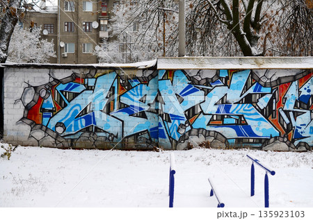 The old wall decorated with paint stains in the style of street art culture. Colorful background of full graffiti painting artwork with bright aerosol outlines on wall. Colored background texture The old wall decorated with paint stains in the style of street art culture. Colorful background of full graffiti painting artwork with bright aerosol outlines on wall. Colored background texture 135923103