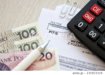 Information on amount of income or loss from non-agricultural economic activity, PIT-B form on accountant table with pen and polish zloty money bills close up Information on amount of income or loss from non-agricultural economic activity, PIT-B form on accountant table with pen and polish zloty money bills close up 135923329