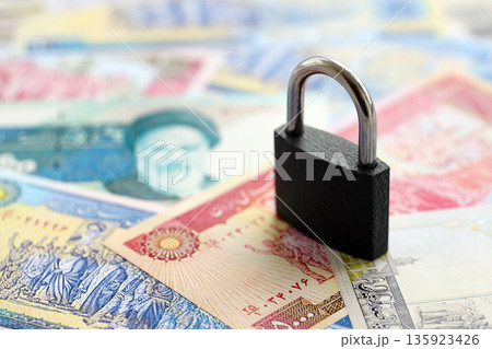 Small padlock lies on pile of iranian money close up. Sanctions, ban or embargo concept 135923426