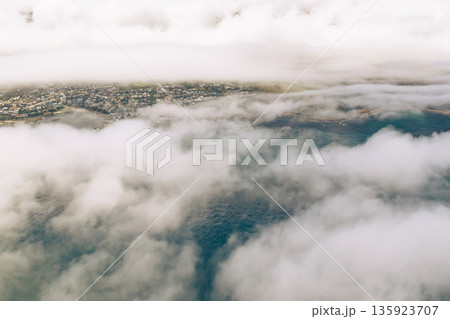 Aerial view of Cape Town covered in low-lying cloud. Cityscape and ocean from above with fog. South Africa luxury travel vacation. 135923707