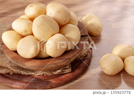 boiled new potatoes, in a wooden bowl, on a rustic table, natural light, no people, 135923778