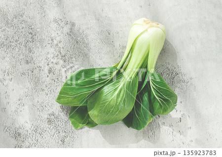 Fresh bok choy, laid out on a light gray surface, top view, natural light, 135923783