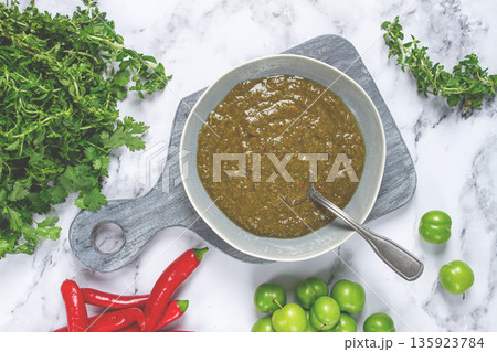 Tkemali sauce, made from green cherry plum, with ingredients on the table, top view, Georgian cuisine, no people, Tkemali sauce, made from green cherry plum, with ingredients on the table, top view, Georgian cuisine, no people, 135923784