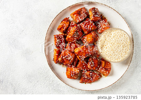 fried pieces of salmon teriyaki with sesame seeds, top view, 135923785