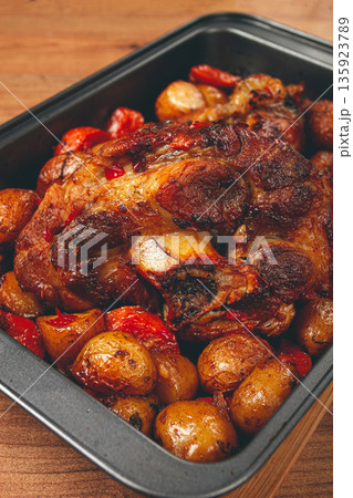 Pork knuckle, baked with vegetables, new potatoes , on a baking sheet, homemade, no people, 135923789