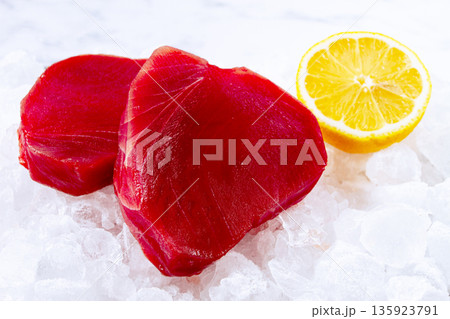 Fresh tuna and lemon, on ice ready, for preparation, at a seafood market 135923791