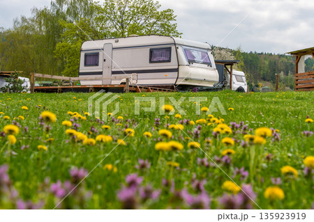 Vintage caravan in green spring meadow with blooming wildflowers at tranquil countryside campsite Vintage caravan in green spring meadow with blooming wildflowers at tranquil countryside campsite 135923919