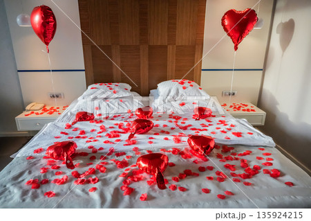 Bed Covered with Rose Petals and Heart Balloons Bed Covered with Rose Petals and Heart Balloons 135924215
