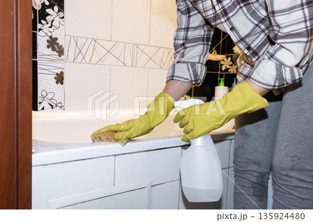 woman washes the bathroom after bathing the dogs.  135924480