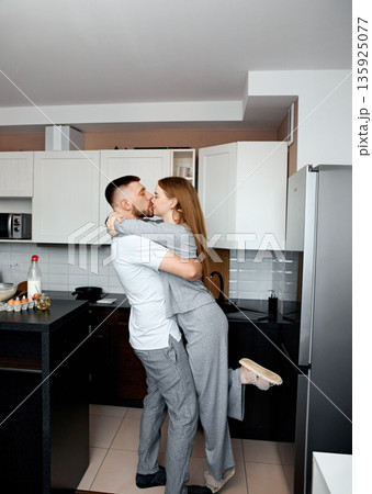 Couple shares a moment in kitchen while embracing during morning in cozy apartment Couple shares a moment in kitchen while embracing during morning in cozy apartment 135925077