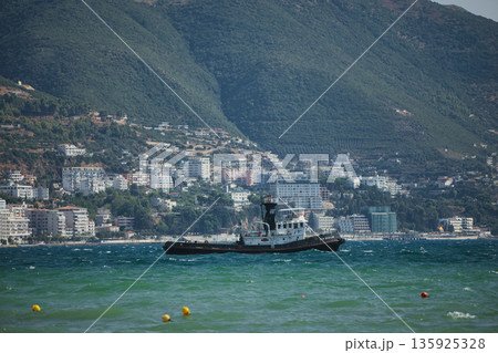 An evening view of the coastline of Vlora, Albania, taken in August 2025. Soft sunlight illuminates the rocky hills and seascape. 135925328