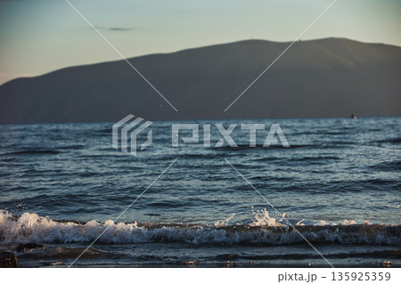 An evening view of the coastline of Vlora, Albania, taken in August 2025. Soft sunlight illuminates the rocky hills and seascape. An evening view of the coastline of Vlora, Albania, taken in August 2025. Soft sunlight illuminates the rocky hills and seascape. 135925359
